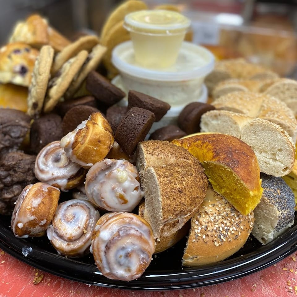 A platter of Redhouse Bagels' assorted baked goods, including bagels, muffins, cookies, and cinnamon rolls.