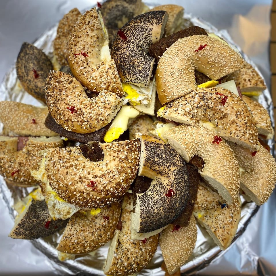 A platter of Redhouse Bagels Bensalem bagel sandwiches, cut in half, with various toppings and fillings.